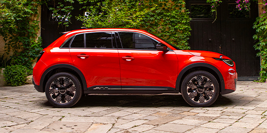 Rød Fiat 600e står parkert sett fra siden