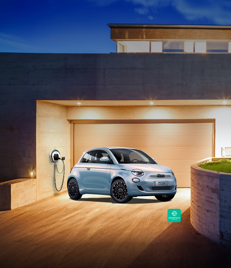 Blå Fiat 500e står parkert og lader på en gårdsplass